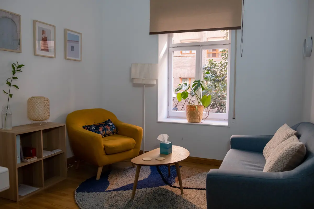 Consulta de El Nido — sillón mostaza y ventana